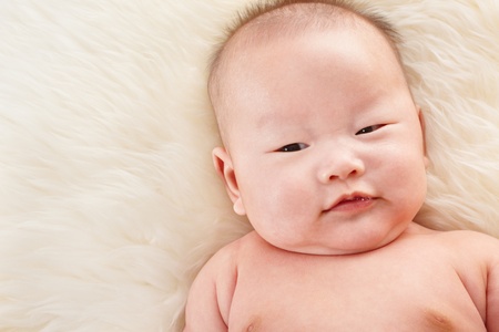 Cute Chinese baby boy, taken close up with fur backgroundの写真素材