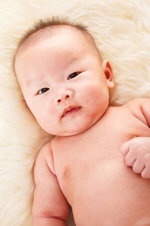 Close up phto shoot of Chinese baby boy on fur bedの写真素材