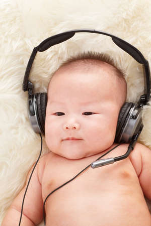 Chinese baby boy listening to music with headphoneの写真素材