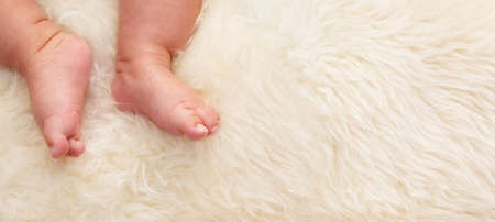 Chinese baby's feet on fur bed wit lots of copy spaceの写真素材