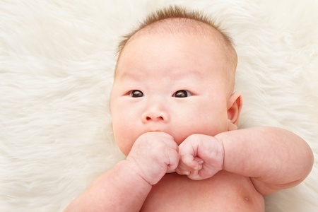 Close up phto shoot of Chinese baby boy on fur bedの写真素材