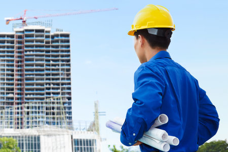 Male contractor or civil engineer looking at the bulding project on progress