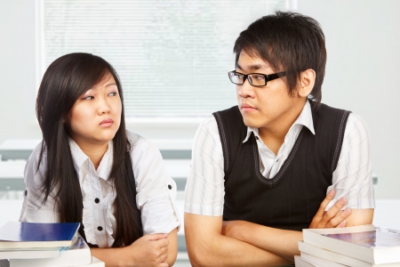 Male and female student looking each other full of hatredの写真素材