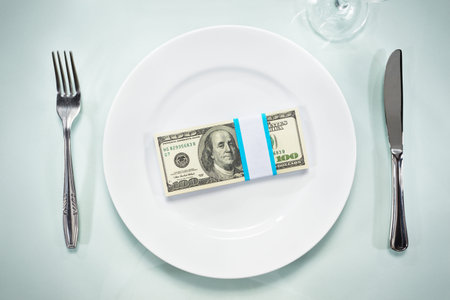 US $ 100 bills on the plate, setting on the glass tableの写真素材