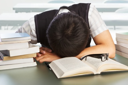 Male college student fall asleep on the tableの写真素材