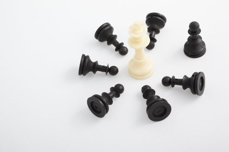 King pieces standing surrounded by fallen other color chess pieces
