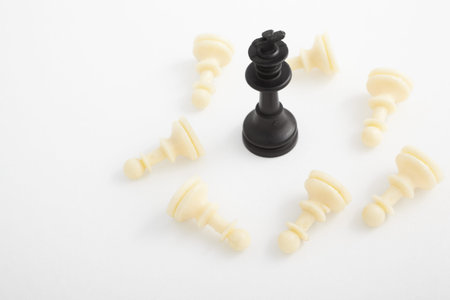 King pieces standing surrounded by fallen other color chess pieces