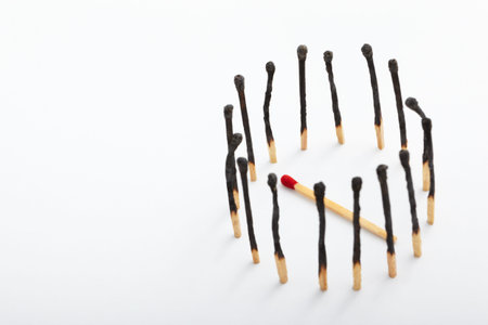 The fallen red tip match being surrounded by the burnt ones