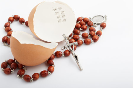 Roman number forty marked inside an empty egg shell, with rosary necklace