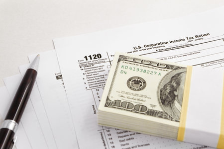 dollar bills over the tax form with  pen