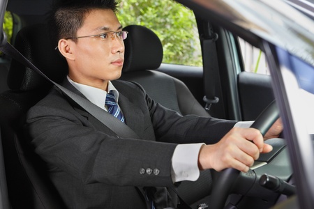 Chinese businessman driving a car looking to the frontの写真素材