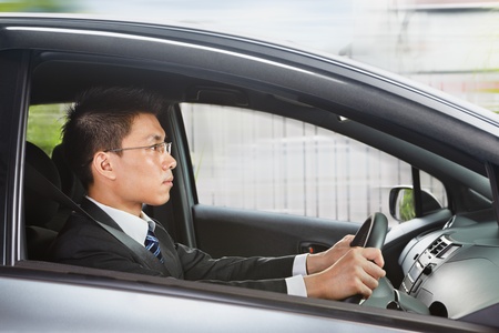 Chinese businessman driving a car looking to the frontの写真素材