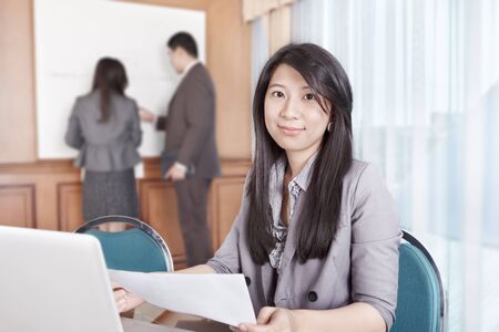 Chinese businesswoman smiling to the camera in the officeの写真素材