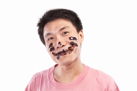 Chinese man which his face spread of chocolate, isolated on white backgroundの写真素材