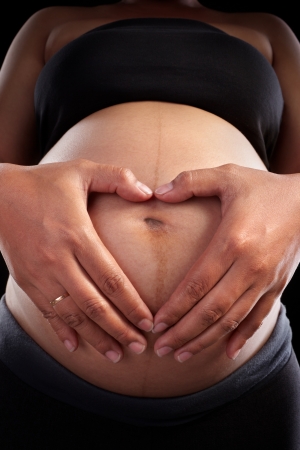 Pregnant lady's stomach over black backgroundの写真素材