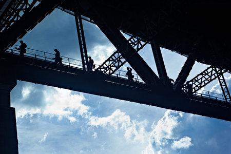 Silhouette of worker crossing the pillar of the constructed bridge