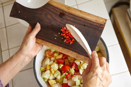Mixing fresh fruit and vegetables for salad