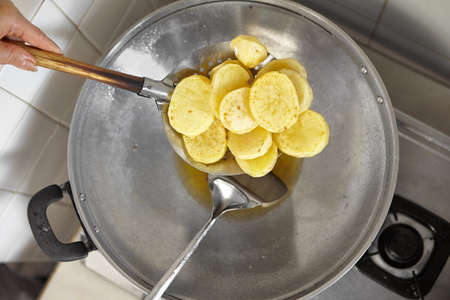 Frying the big slice potato in a wokの写真素材