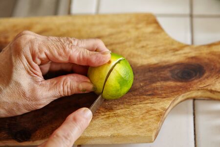 Cutting lime on the wooden cutting boardの写真素材