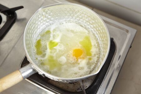 Adding egg to the boiled stock soupの写真素材