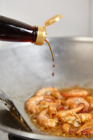 Adding spices to the cooking on the wokの写真素材