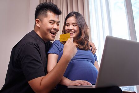 Asian young couple buying online to prepare for the babyの写真素材