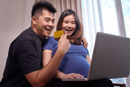 Asian young couple buying online to prepare for the babyの写真素材