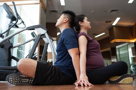 Asian young couple doing exercise while the lady pregnantの写真素材