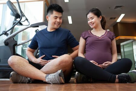 Asian young couple doing exercise while the lady pregnantの写真素材