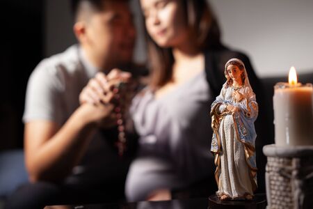 Young asian couple praying for the baby in the wombの写真素材