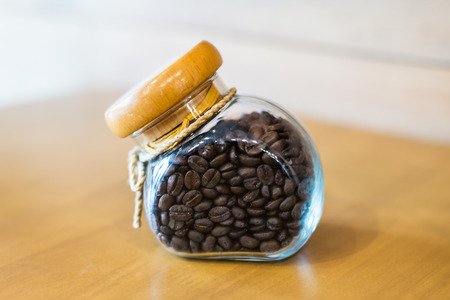 coffee beans in a bottle decoration on wooden tableの写真素材