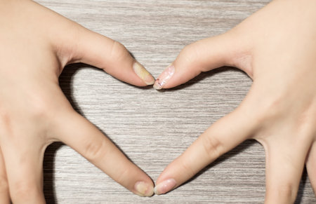 Hand make a heart on wooden background