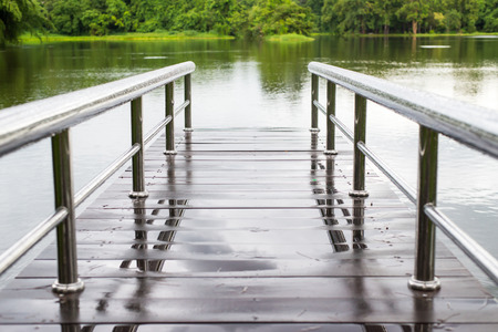 bridge over a dam near the tropical mountain , rainy dayの写真素材