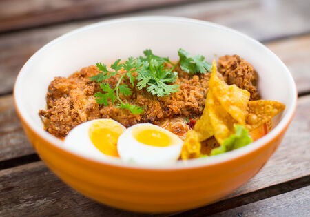 Asian noodles with fried pork on wooden backgroundの写真素材