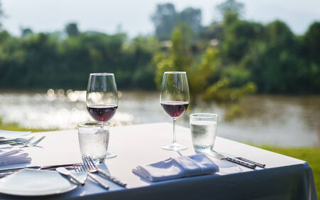 red wine on table set and  green grass background in the gardenの写真素材
