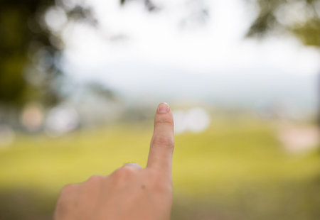 Hand pushing on nature bokeh background