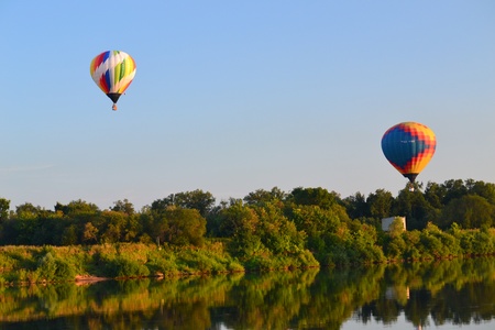 Beautiful colored aerostats flying over the riverのeditorial素材