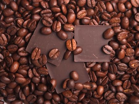 background of the coffee beans and pieces of chocolateの写真素材