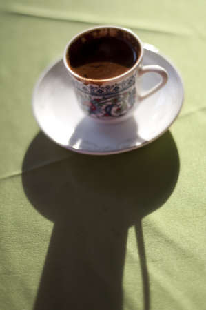 Turkish coffee cup on tablecloth with shadowの写真素材