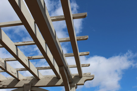 Looking up at sky through slats of a pergolaの写真素材