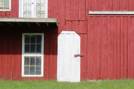 Red painted barn with white door and window trimの写真素材