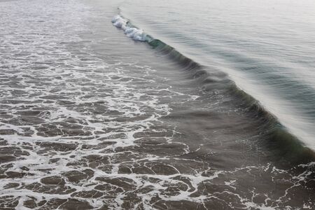 Ocean wave and swell approaching from right in the morning, horizontal aspectの写真素材