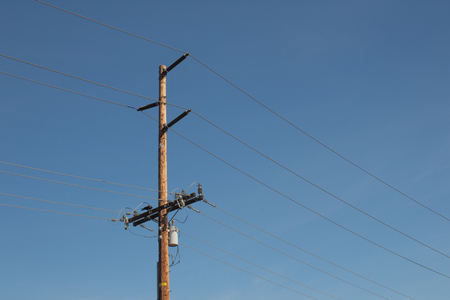 High voltage power lines and pole against a deep blue sky, copy space, horizontal aspectの写真素材