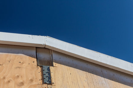 Residential construction detail with bracket for laminated ridge beam, plywood sheathing, copy...