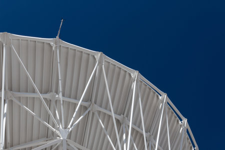 Very Large Array graceful arch of a large radio telescope dish against blue sky, science...