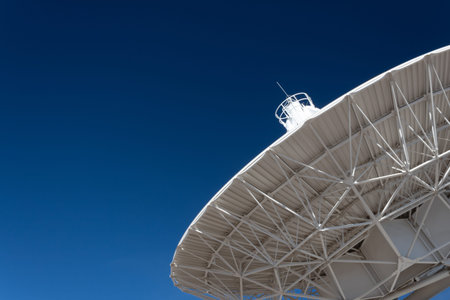 Very Large Array understructure of a radio telescope antenna dish pointing into a deep blue sky,...