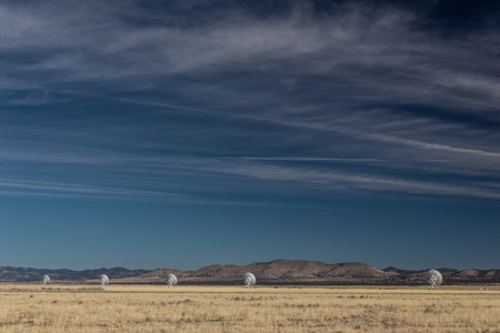 Very Large Array line of radio astronomy observatory telescopes in the New Mexico desert, copy space in blue sky, horizontal aspectの写真素材