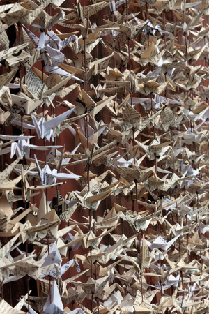 Deep view of 1000 folded paper origami cranes sculpture from vintage ephemera, selective focus, vertical aspectの写真素材