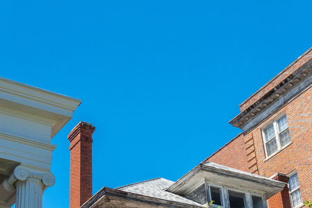 Mix of architecture with Ionic columns, abandoned house with very tall chimney, and brick apartment buildings, horizontal aspectの写真素材