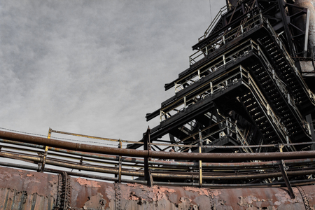 Sweeps of industrial pipes and stairs, derelict steel mill, horizontal aspectの写真素材